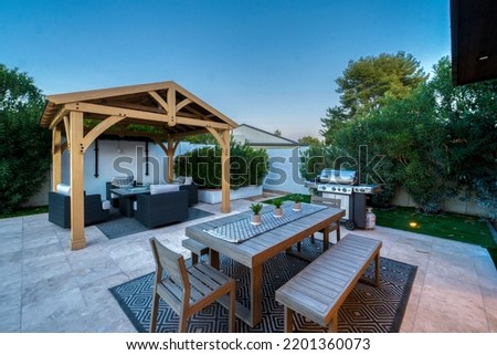 a luxury back patio with a pool in the evening  Royalty-Free Stock Photo #2201360073