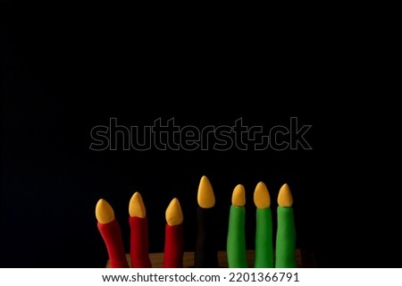 Kinara. Traditional Kwanzaa symbols. Isolated on black background. African American holiday. Hand-sculpted kinara from plasticine