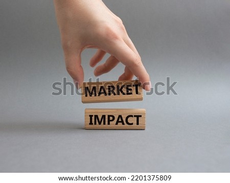 Market impact. Concept word Market impact on wooden cubes. Beautiful grey background. Businessman hand. Business and Market impact concept. Copy space.