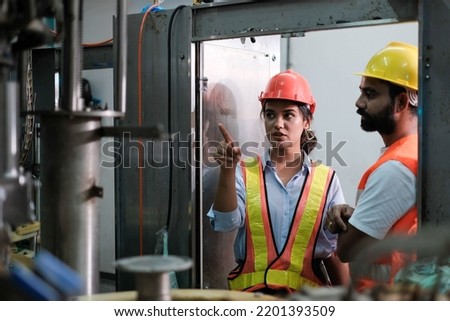 engineer worker working together with safety uniform and white helmet to work in industry factory handle tablet. Factory worker inspecting production line of drink production in factory. indian men Royalty-Free Stock Photo #2201393509