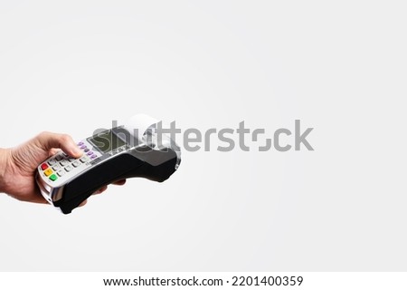 Cash terminal in a man's hand. Isolated on white background. Bank and credit cards, shops, cafes, online purchases and sales. Minimalism. There is free space to insert.