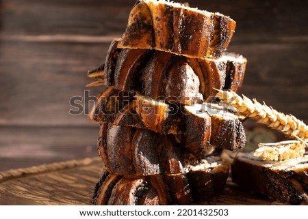 Appetizing bun with poppy seeds on an old background