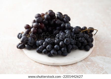 Dark grape on a white desk