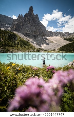 A tourist exploring the beatiful teal waters of Lake Sorapis, Northern Italy