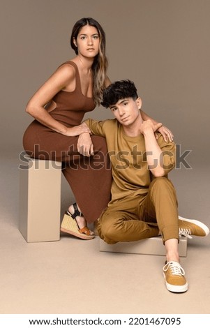 Full length shot of a Puerto Rican woman in her 30's and a non-binary Caucasian person in their 20's posing confidently on a neutral background. Royalty-Free Stock Photo #2201467095