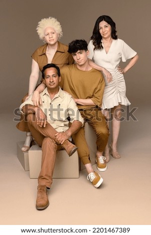 Portrait of a Black woman with albinism in her 20's, a Hispanic woman in her 50's, a non-binary Caucasian person in their 20's, and an Indian man in his 50's confidently looking at the camera. Royalty-Free Stock Photo #2201467389
