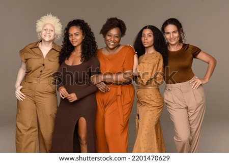 Three quarter length shot of a group of beautiful multiracial women standing confidently on a neutral background.