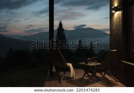 Wooden chairs and table set on terrace evening after sunset