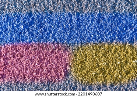 structure of an old road surface with a blue stripe and fragments of yellow and red
