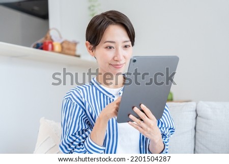 Asian woman looking at tablet PC