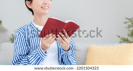 Asian woman reading a book in a room