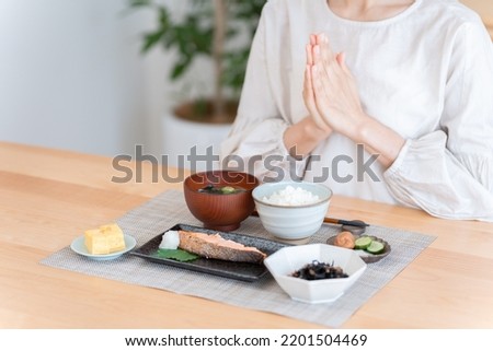 Asian woman eating a meal Royalty-Free Stock Photo #2201504469