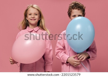 funny little kids put on colored balloons standing on a pink background. empty space for inserting an advertising layout