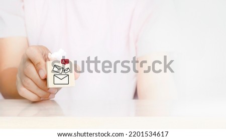 Businessman chooses email icons being notification bell for incoming mail messages. Hand holding wood cube block