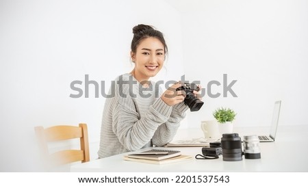 Portrait beautiful asian photographer creative woman working in office holding camera laptop. Business people employee freelance online marketing. Successful freelance creative artist girl business.
