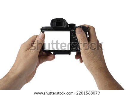 a man holds a mirrorless camera with his hands on a white background
