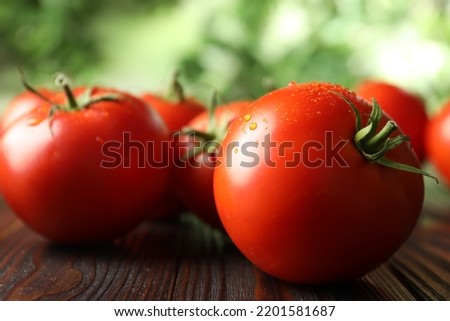 Fresh ripe tomatoes on wooden table, closeup