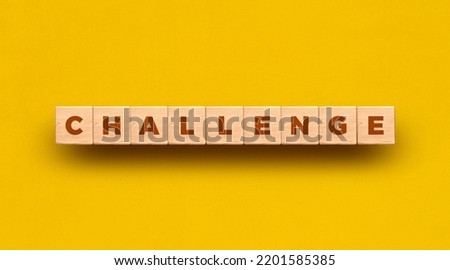 Challenge word written on wooden blocks with yellow background