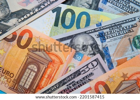 banknotes of 100 dollars and 100 euros on a blue background. EUR USD exchange rate. Trade relations between the US and Europe Royalty-Free Stock Photo #2201587415