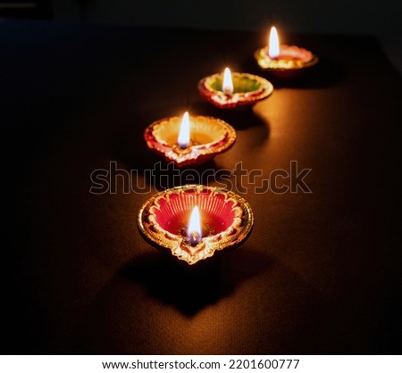 Happy Diwali. Deepavali Hindu festival of lights. Clay diya candle. Oil lamp lit on dark background, copy space. 
 Royalty-Free Stock Photo #2201600777