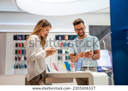 Happy young people shopping new mobile phone in a store. People technology device new concept