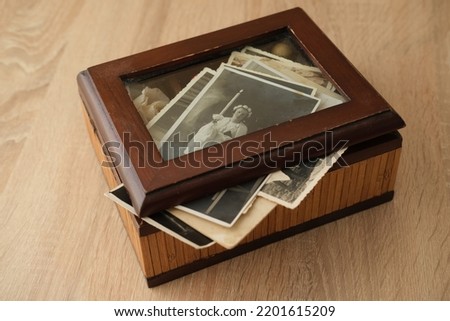 close-up old vintage photos 50s, 60s sepia color in brown wooden box, chest, concept of antique treasure, family tree, genealogy, memory of ancestors, family ties, childhood memories