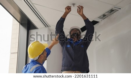 Engineers team installing fire sprinkler in office at building site, Technicians workers checking fire alarm systems and automatic sprinkler systems at new building construction site Royalty-Free Stock Photo #2201631111