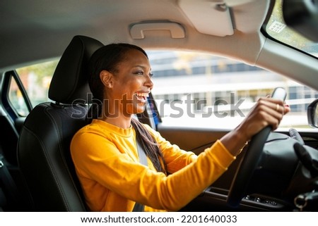 Portrait of joyful young african american woman driving a car Royalty-Free Stock Photo #2201640033