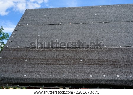 roof covered with tar paper, black tar paper on the roof Royalty-Free Stock Photo #2201673891