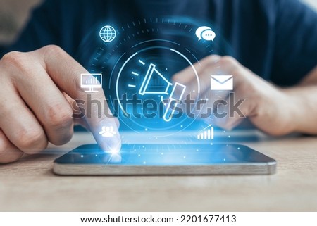 Advertising and marketing as tools for global trade. Person touches smartphone with hologram Royalty-Free Stock Photo #2201677413