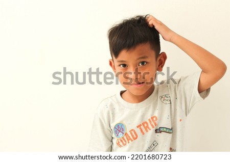 frustrated and confused asian boy who grimaced and looked at the camera, scratched his head, had a confused facial expression, forgot something important. isolated white background Body language