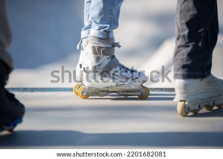Roller blader wearing white aggressive inline skates in skatepark