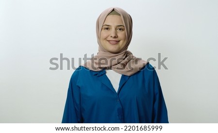 Happy and cheerful young woman in hijab laughing out loud. Woman posing in studio portrait isolated on white background. Portrait showing the feeling of shock or wow in the face of surprise. Royalty-Free Stock Photo #2201685999