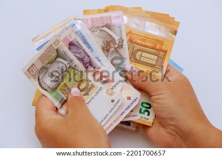 Euro and kuna in the hands of a tourist on a white background. Currency of Croatia and Europe. Royalty-Free Stock Photo #2201700657