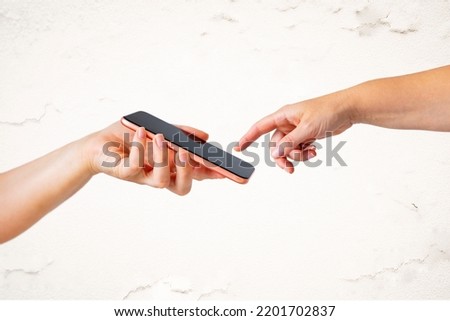 Appropriation of famous Michelangelo's painting The Creation of Adam with God's finger reaching to the screen of mobile phone Royalty-Free Stock Photo #2201702837