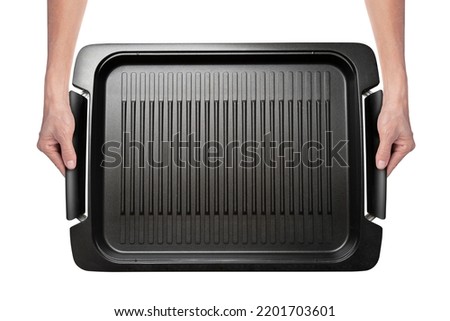 Close up of hands holding a large grill tray, ready to serve. Isolated on white with clipping path. Top view. Royalty-Free Stock Photo #2201703601