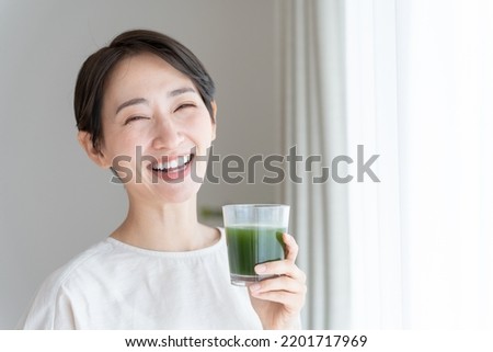 Asian woman drinking vegetable juice Royalty-Free Stock Photo #2201717969