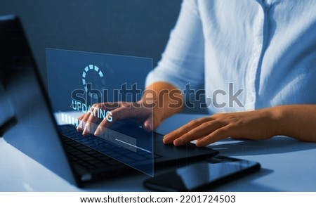 Concept of updating the operating system with a newer, better and improved version.Software update.  Updating progress bar on virtual screen.  Royalty-Free Stock Photo #2201724503