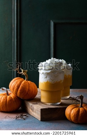 Spicy pumpkin latte with whipped cream. Autumn or winter hot coffee drink with cinnamon, nutmeg 
