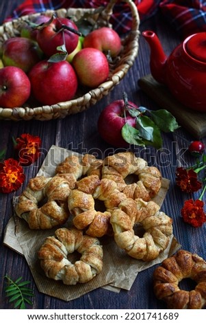 Homemade cake with apples and red apples in a basket on a rustic background. Season, harvest.