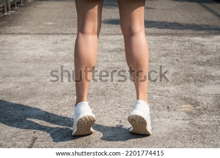 Cropped shot of female runner standing on her tiptoes for strengthen her calves. Toe stretches can help keep you healthy and prevent common runner injuries. Royalty-Free Stock Photo #2201774415