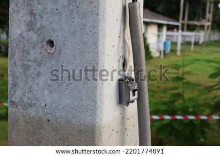 Old, broken electrical wires installed at outdoor cement poles. dangerous area