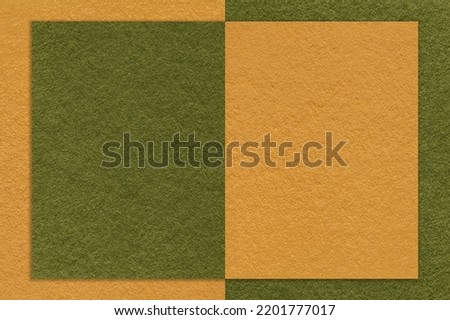 Texture of yellow and dark green paper background with geometric shape and pattern, macro. Structure of craft olive cardboard with frame. Felt abstract backdrop with autumn shade.