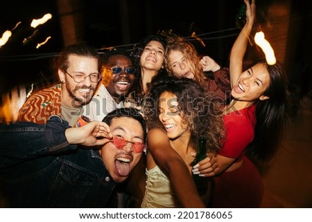 A group of multiracial friends has a great time at the roof nightclub in the summertime. Clubbing, fun, and parties during the summer concept. Royalty-Free Stock Photo #2201786065
