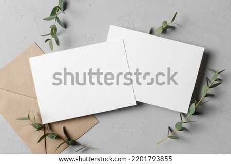 Iinvitation card mockup with envelope and eucalyptus twigs, front and back sides