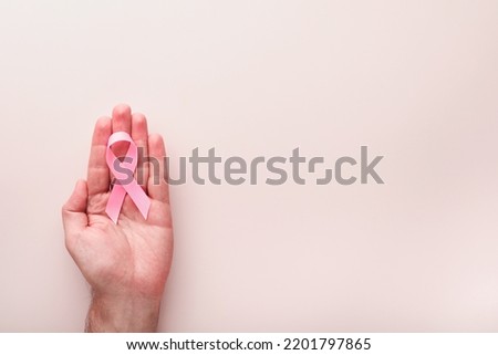 Pink Breast Cancer Awareness Ribbon. Hands holding pink ribbon on backgrounds. Breast cancer awareness and October Pink day, world cancer day. Top view. Mock up. Royalty-Free Stock Photo #2201797865