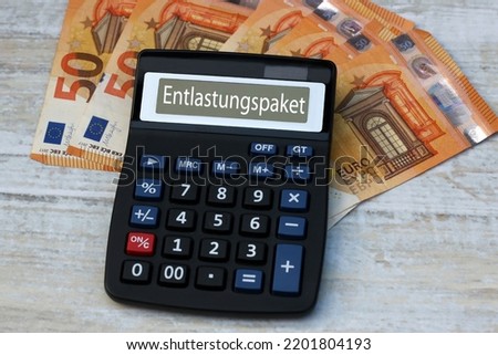 Calculator with the word Entlastungspaket on the display with Euro banknotes, Entlastungspaket means translated relief package. Royalty-Free Stock Photo #2201804193