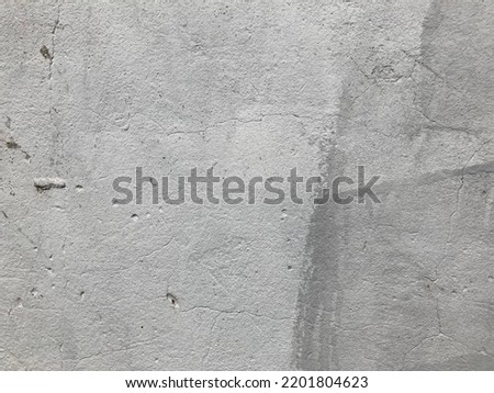 Grunge grey concrete background. A fragment of a wall with scratches and chips on the surface.