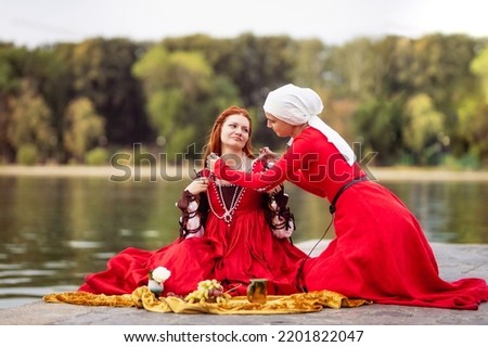 Images of a wealthy Venetian lady and her maid   in fashion of the 15th century.Maid giving pearl beads to mistress Royalty-Free Stock Photo #2201822047