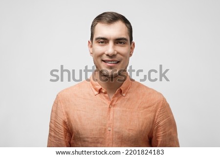 smiling handsome caucasian man about 30 years old in orange shirt on white background, male portrait Royalty-Free Stock Photo #2201824183